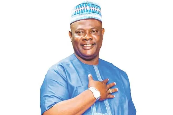 Yinka Quadri in a blue traditional outfit during an interview, smiling for the camera.